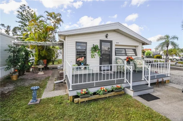 View of front facade with a wooden deck and a front lawn