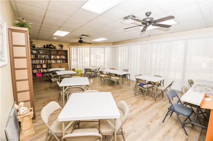 Dining area with a drop ceiling, a ceiling fan, and light wood-style flooring