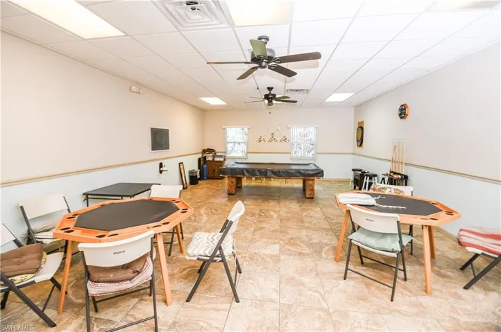 Game room with ceiling fan and a drop ceiling