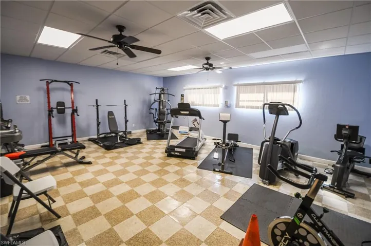 Exercise area featuring a drop ceiling and a ceiling fan