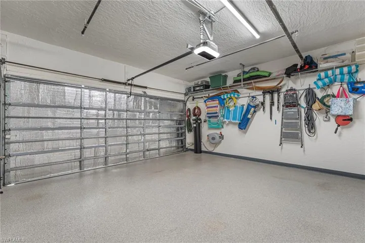 The two-car garage features an insulated door, epoxy-finished flooring, and ample additional storage.