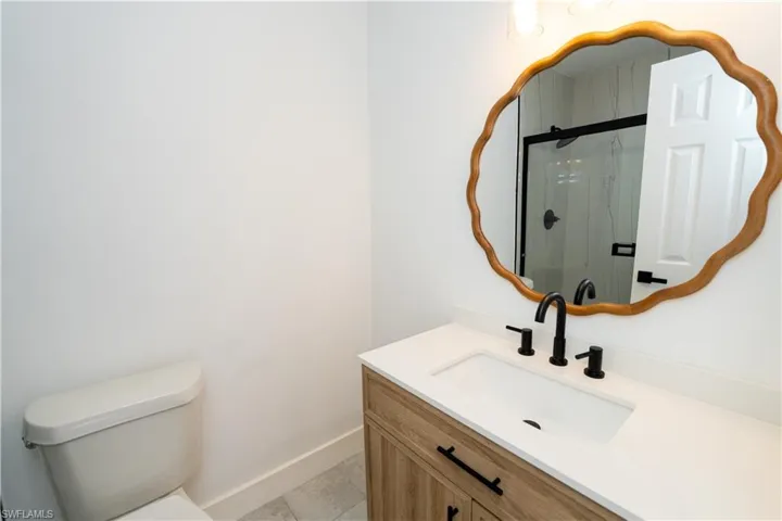 Bathroom featuring a single vanity with wood-finish cabinetry, a white countertop, and a rectangular undermount sink