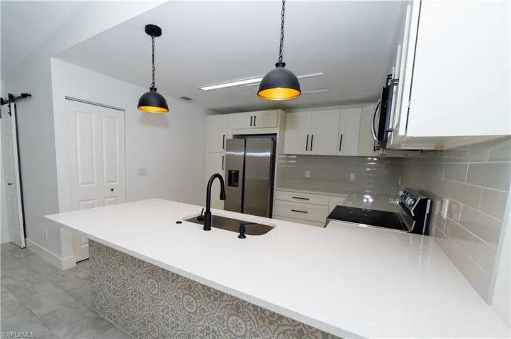 Kitchen island with a white solid surface countertop and undermount sink