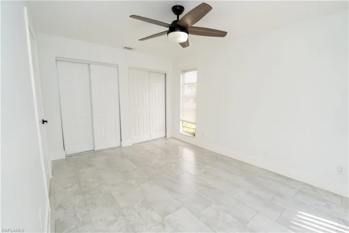 Bright interior space featuring light-toned tile flooring and white baseboards