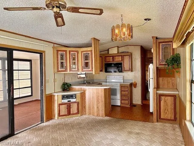Kitchen with white electric range oven, ceiling fan with notable chandelier, light parquet flooring, a textured ceiling, and fridge