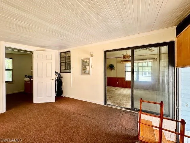 Unfurnished room with wood ceiling and carpet floors