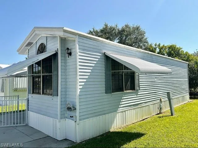 View of property exterior with a yard