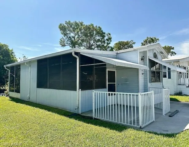 Back of property with a sunroom and a yard