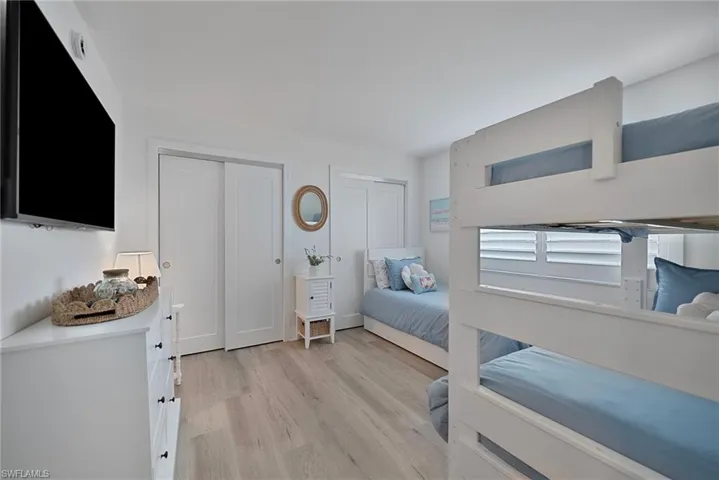 Bedroom with two closets and light wood-style floors