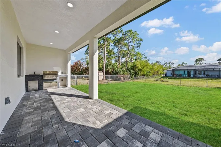 Fenced backyard featuring exterior kitchen, a patio, and a shed