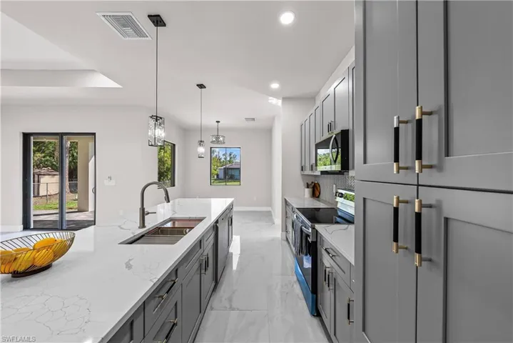 Kitchen featuring light stone counters, gray cabinetry, electric range, pendant lighting, and black microwave