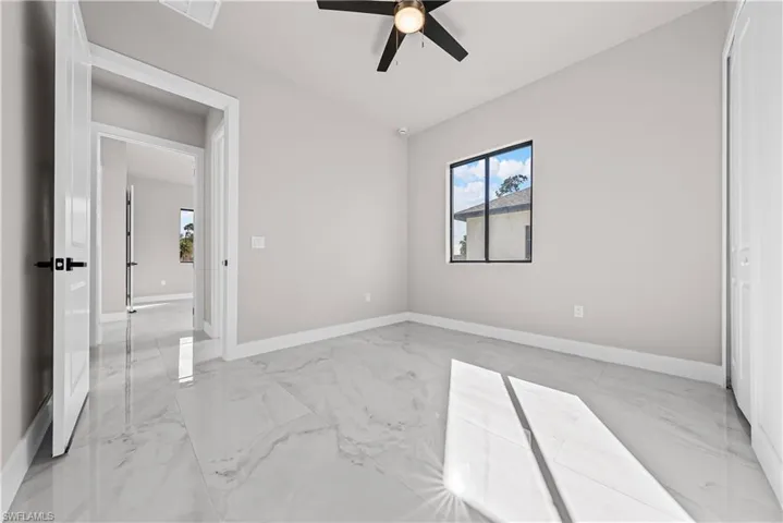 Unfurnished bedroom featuring light marble finish flooring and a ceiling fan