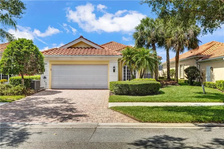 Mediterranean / spanish-style home with a tile roof, decorative driveway, cooling unit, a garage, and a front yard