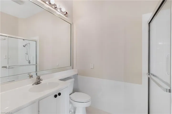 Master Bathroom with vanity, toilet, and a shower with door