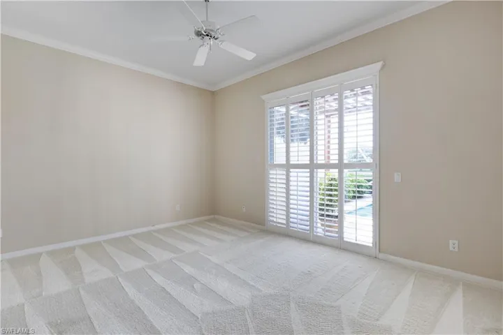 MB featuring light colored carpet, ornamental molding, ceiling fan, and baseboards, Plantation shutters on sliders