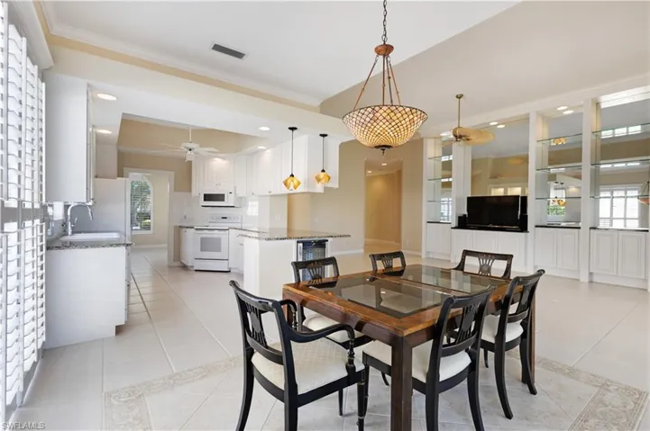 Dining space with ceiling fan, light tile patterned flooring, ornamental molding, and plenty of natural light with Plantation Shutters