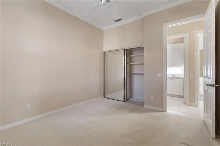 3rd bedroom featuring light colored carpet, crown molding, baseboards, a closet, ceiling fan and Plantation shutters