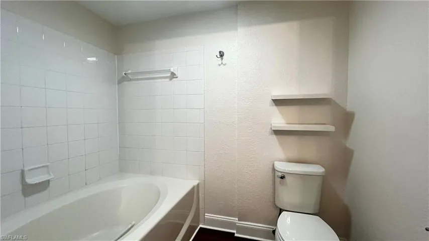Bathroom with toilet and tiled shower / bath