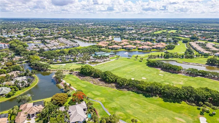 Expansive golf course and water features surrounded by residential properties, mature trees, and lush landscaping