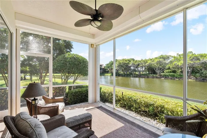 Screened patio featuring a ceiling fan with integrated lighting, tile flooring, and direct water frontage