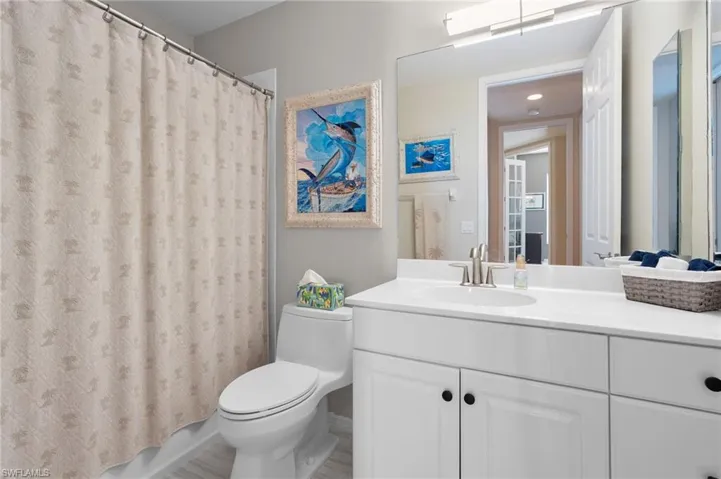 White vanity with a single basin sink, brushed nickel faucet, and integrated countertop