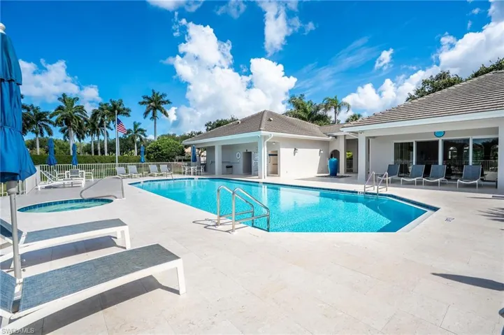 Outdoor swimming pool with integrated spa, surrounded by a light-toned paver deck