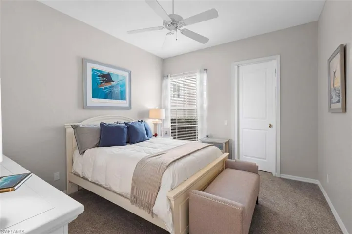 Bedroom with neutral wall tones and textured carpeting