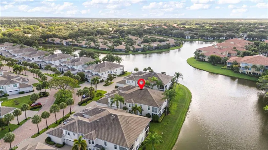 Waterfront property featuring a red tile roof and multiple balconies
