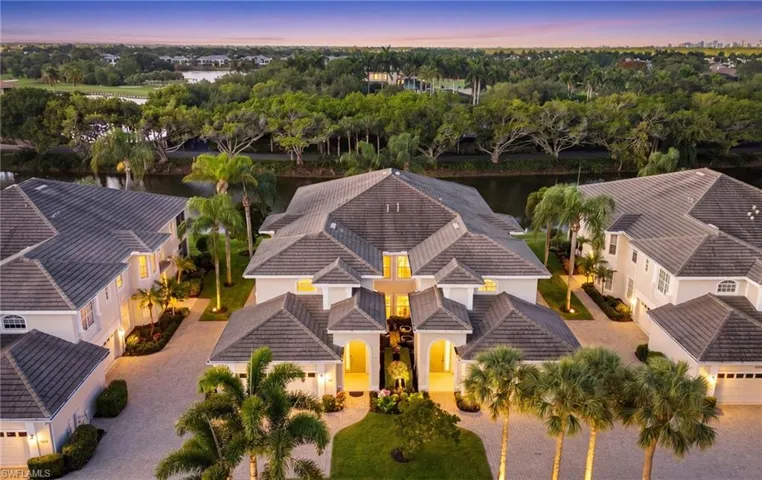 Expansive property featuring a multi-gabled tile roofline and a paver stone driveway