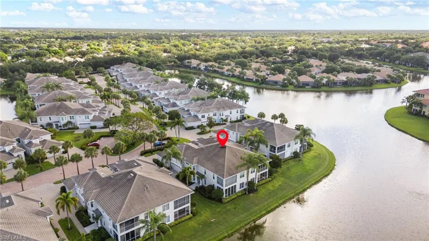 Property featuring a multi-story structure with screened balconies, situated on a waterfront lot