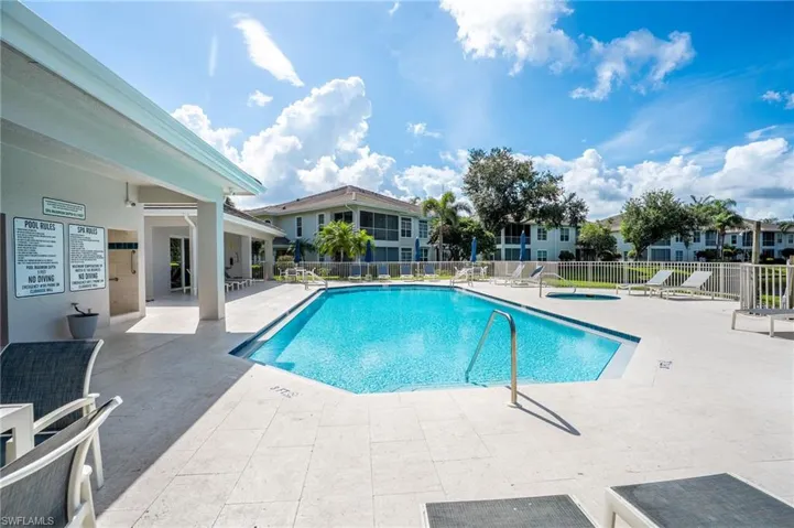 Spacious outdoor pool area featuring an in-ground swimming pool, surrounding patio, and lounge seating