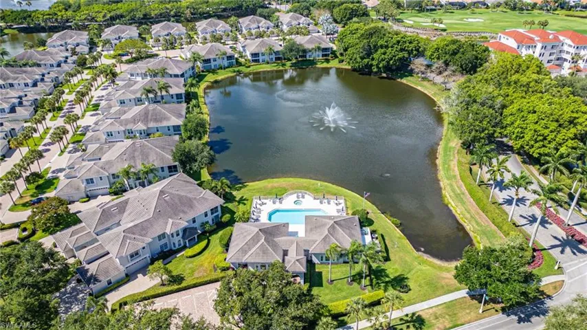 Aerial perspective showcasing a residential community with a central pond featuring a fountain