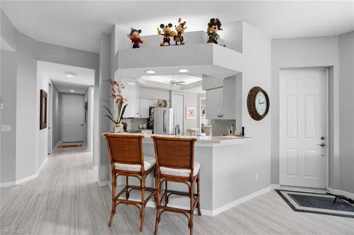Open-concept living space with light finish flooring, white baseboards, and a neutral wall palette