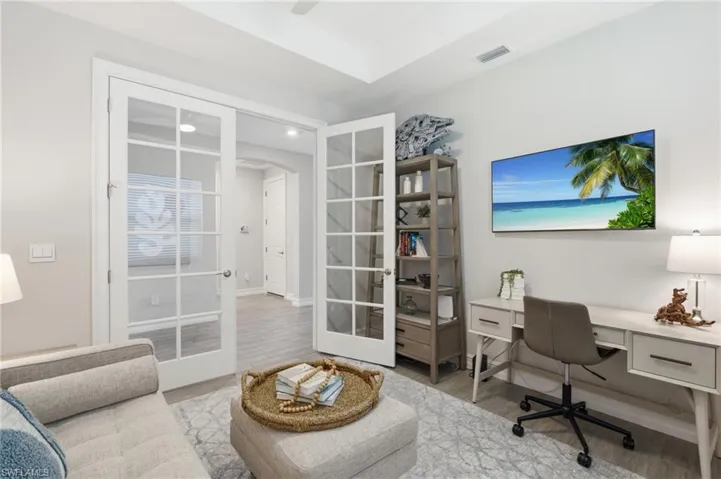 Glass French dual door entry, wood look tile, tray ceiling, ceiling fan