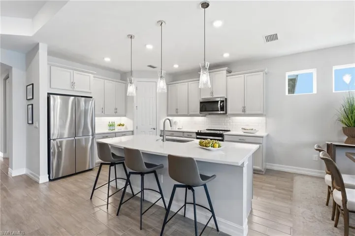Walk in pantry, Quartz countertops, 42 in cabinetry, backsplash, upgraded appliance package, wood look tile flooring