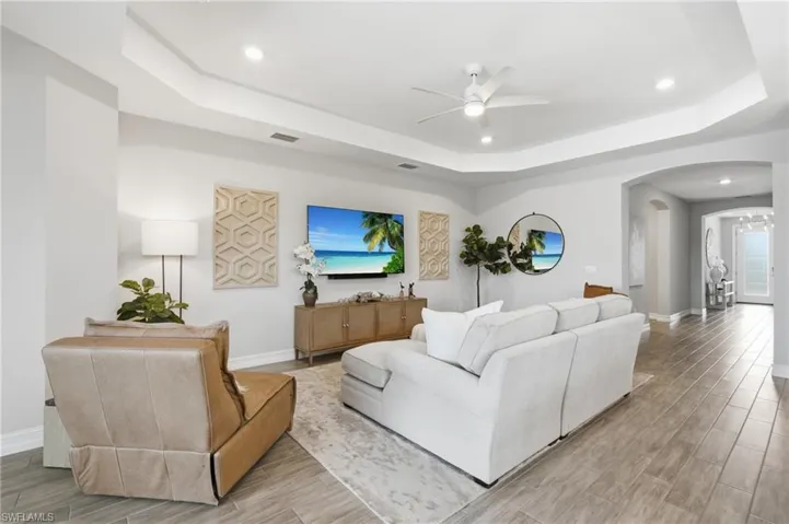 Wood look tile, tray ceiling, leading to den, foyer, guest rooms