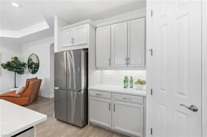 Under cabinet ambient lighting, crown molding on cabinetry, expansive walk in pantry, Samsung stainless refrigerator