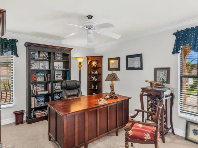 Home office featuring ceiling fan, crown molding, and light carpet