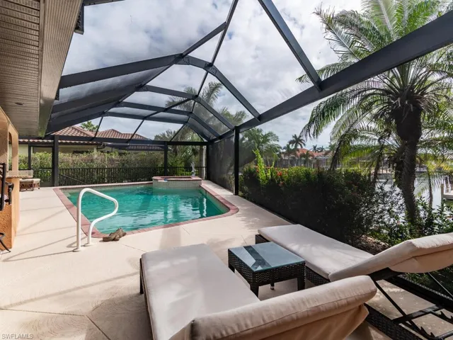 View of swimming pool featuring a patio area and a lanai
