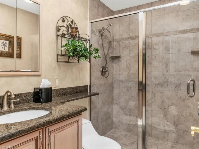 Bathroom with vanity, toilet, and a shower with door