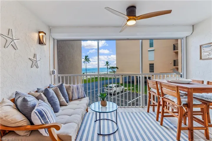 Living room featuring ceiling fan and a water view