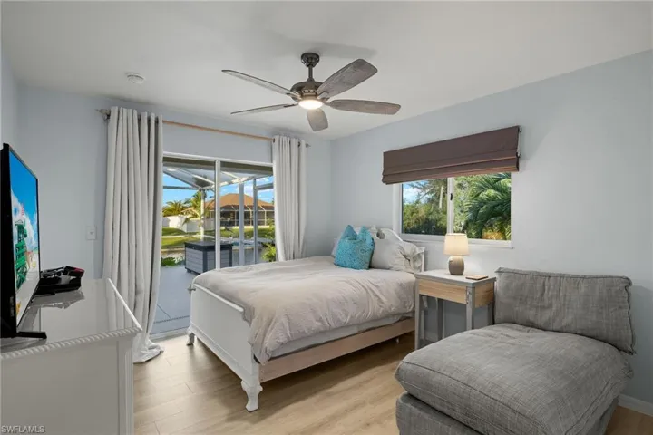 Bedroom with access to outside, light hardwood / wood-style floors, multiple windows, and ceiling fan