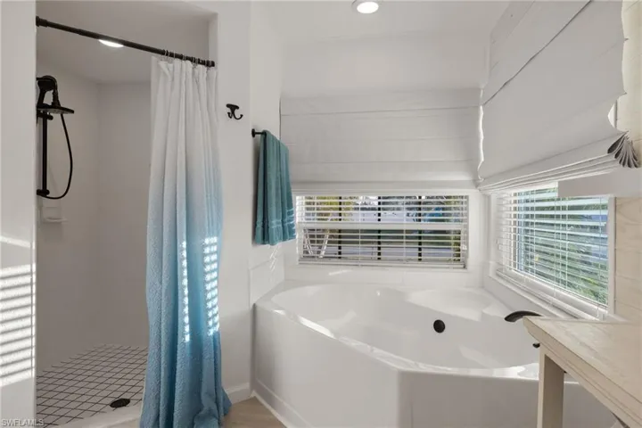 Bathroom featuring shower with separate bathtub