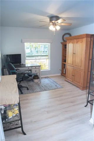 Office area with a ceiling fan and light wood-style floors