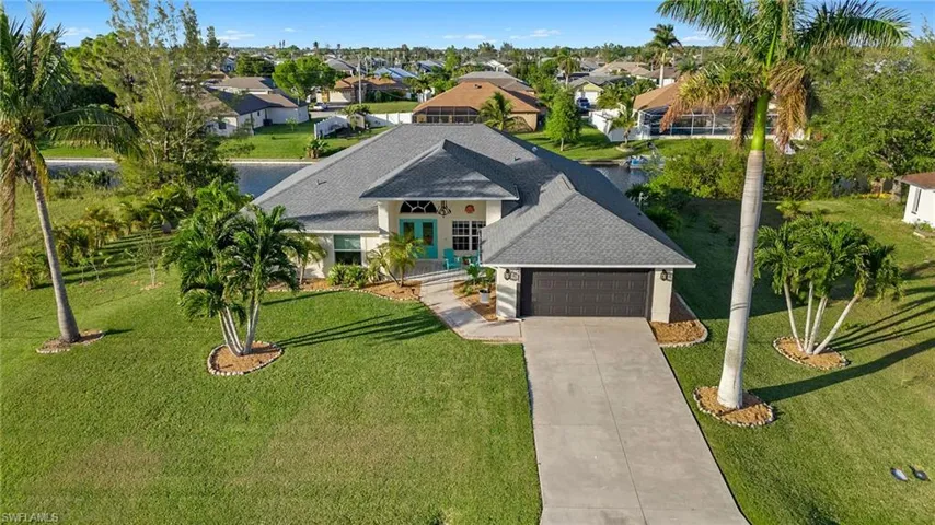 View of front of house featuring a front lawn and a garage