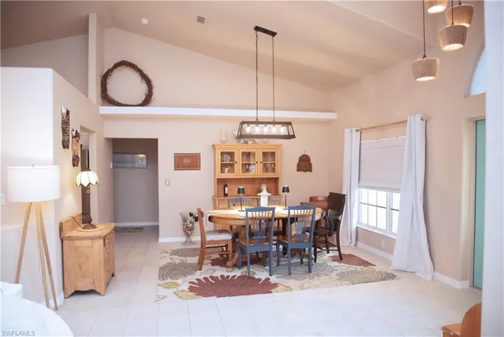 Dining space with lofted ceiling and baseboards