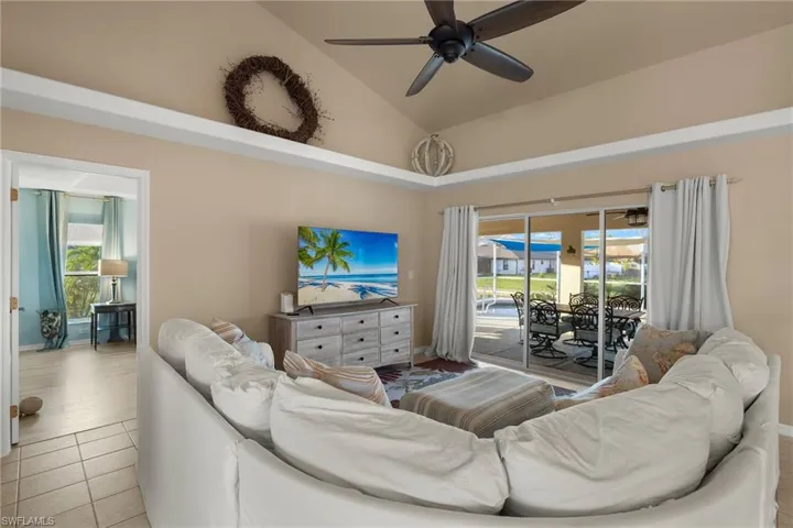 Living room with high vaulted ceiling, light hardwood / wood-style floors, and ceiling fan