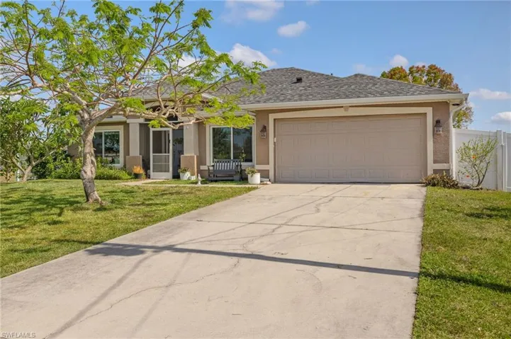 View of front of property featuring stucco siding, concrete driveway, and an attached garage