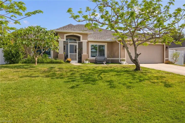 View of front of house featuring stucco siding, concrete driveway, a front yard, a garage, and roof with shingles