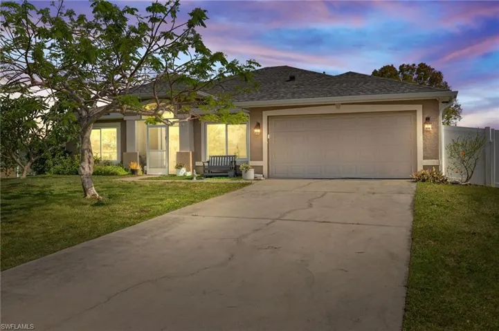 Single story home with stucco siding, driveway, an attached garage, and a shingled roof